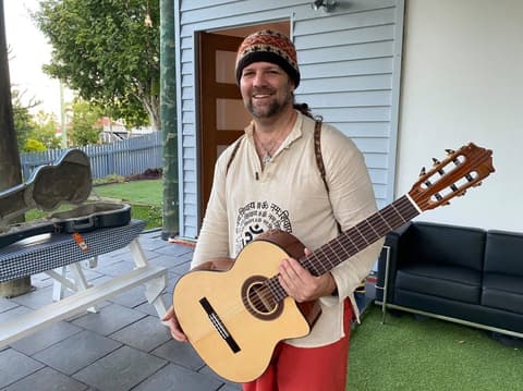 A guest playing guitar in the garden